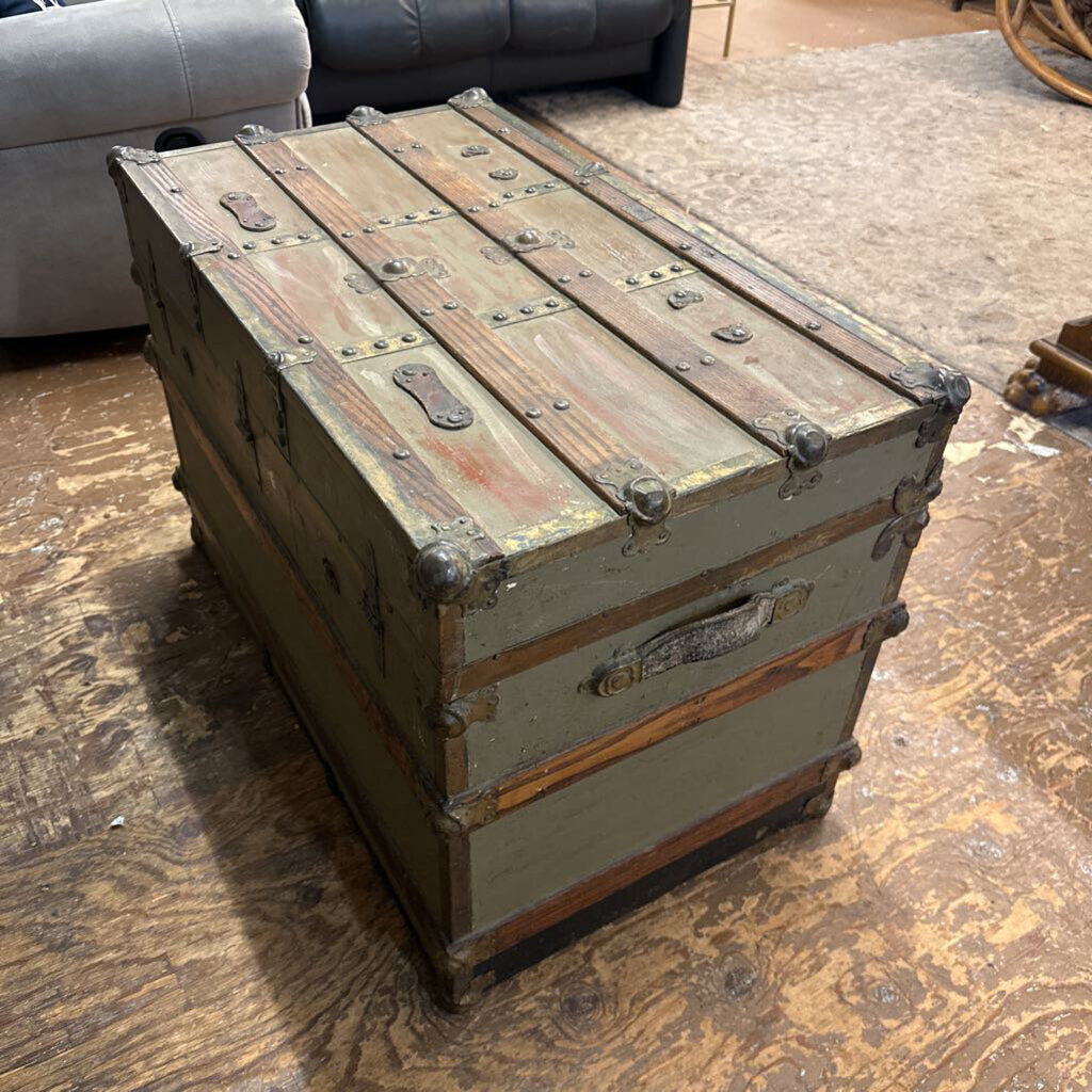 Vintage wooden trunk on a wooden floor with a sofa in the background