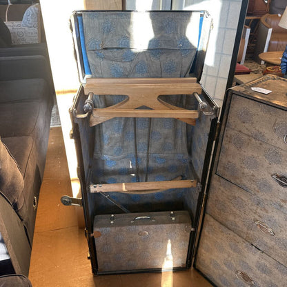 Open suitcase with blue floral pattern on a wooden floor