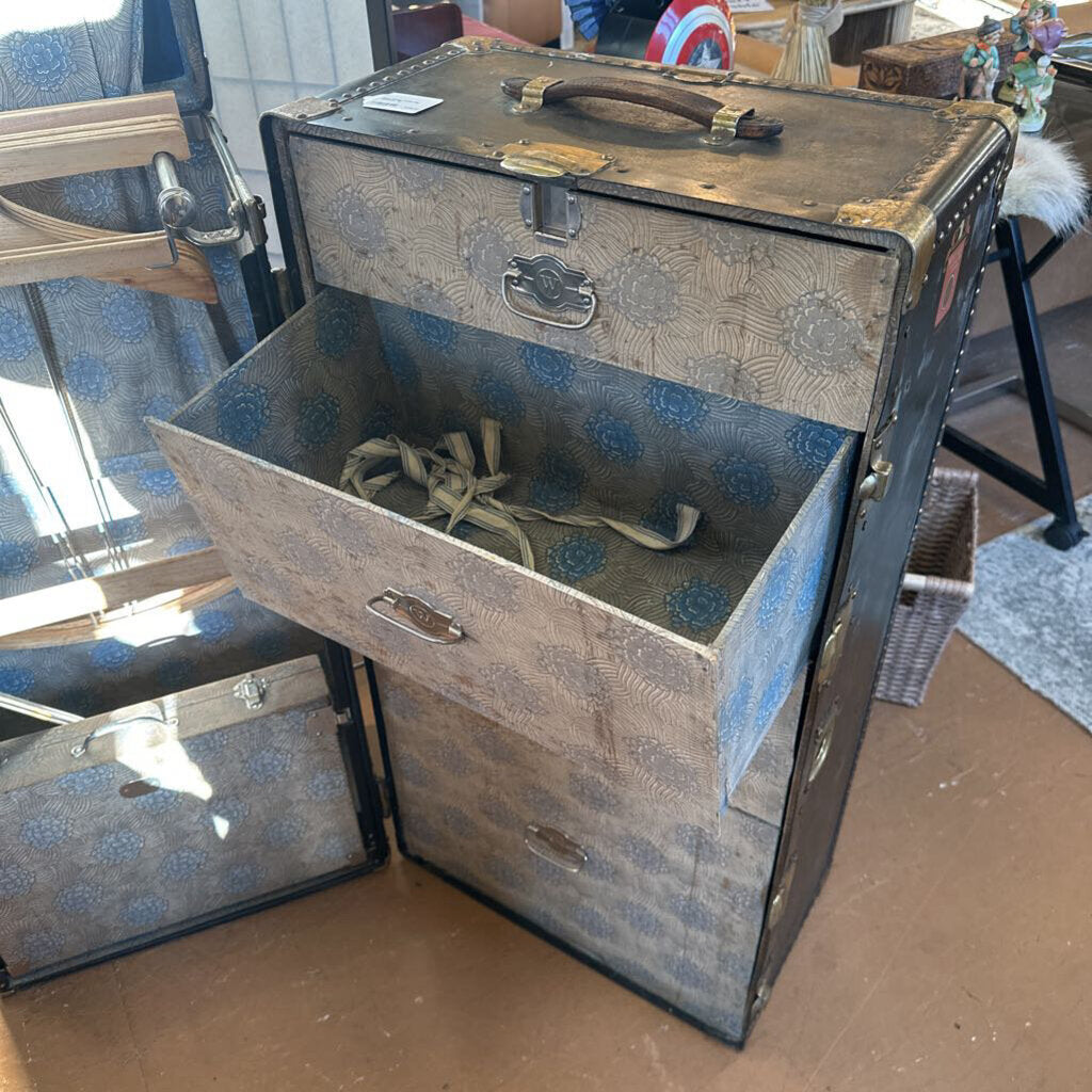 Vintage-style suitcase with floral pattern on a wooden floor