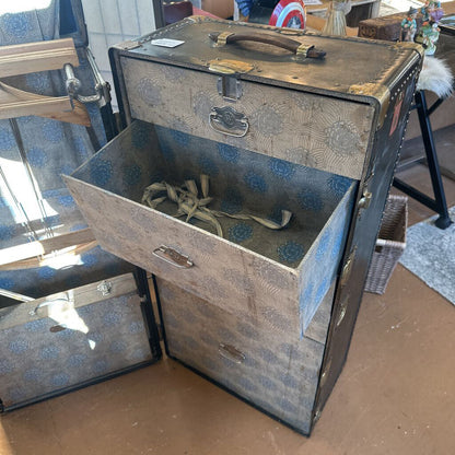 Vintage-style suitcase with floral pattern on a wooden floor