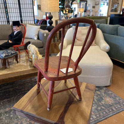 Wooden chair on a wooden platform in a room with furniture and decor.