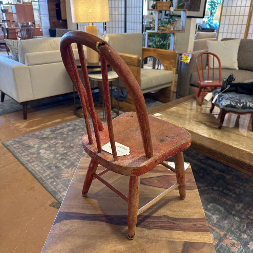Small wooden chair on a platform in a furniture store setting