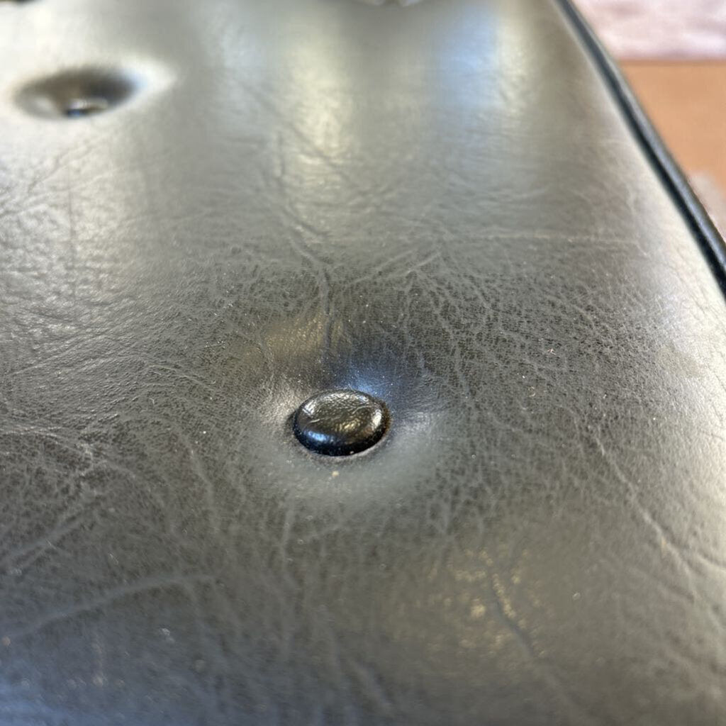 Close-up of a leather surface with a button and visible texture