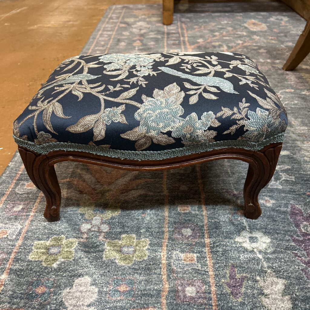 Decorative ottoman with floral pattern on a patterned rug
