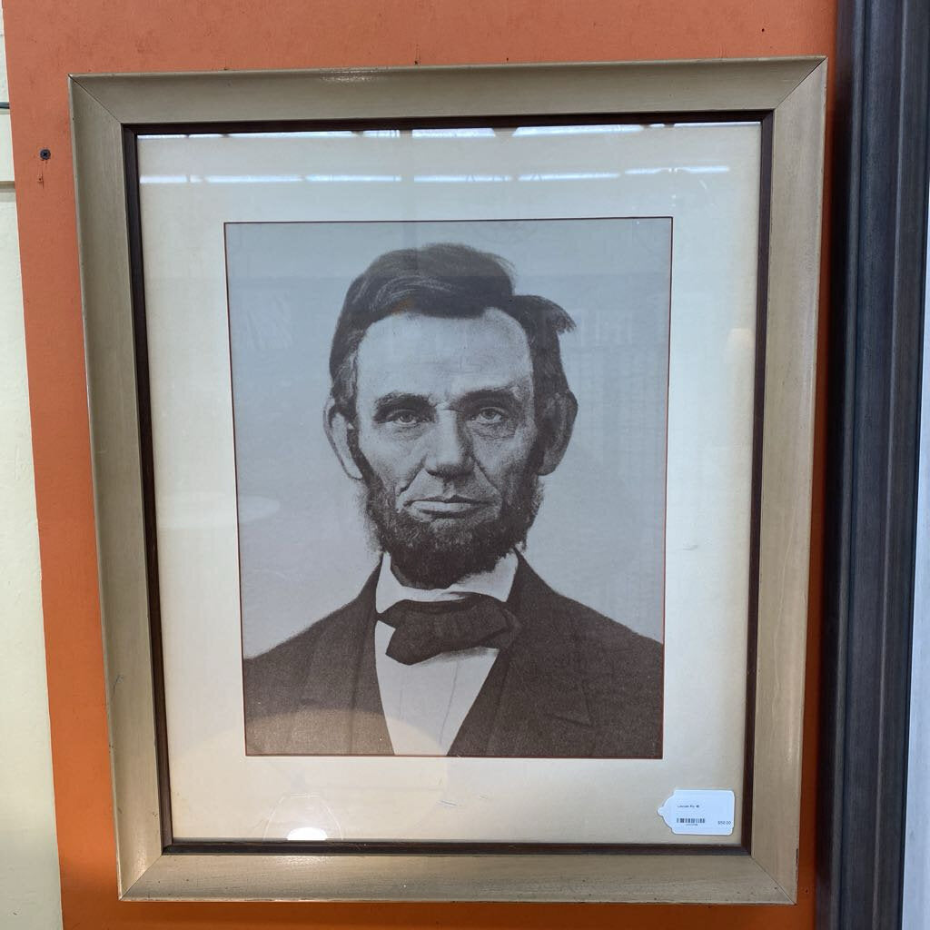 Framed black and white portrait of a historical figure with a red border.