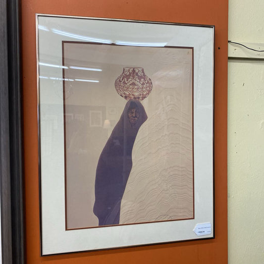 Framed artwork with a vase on a textured surface