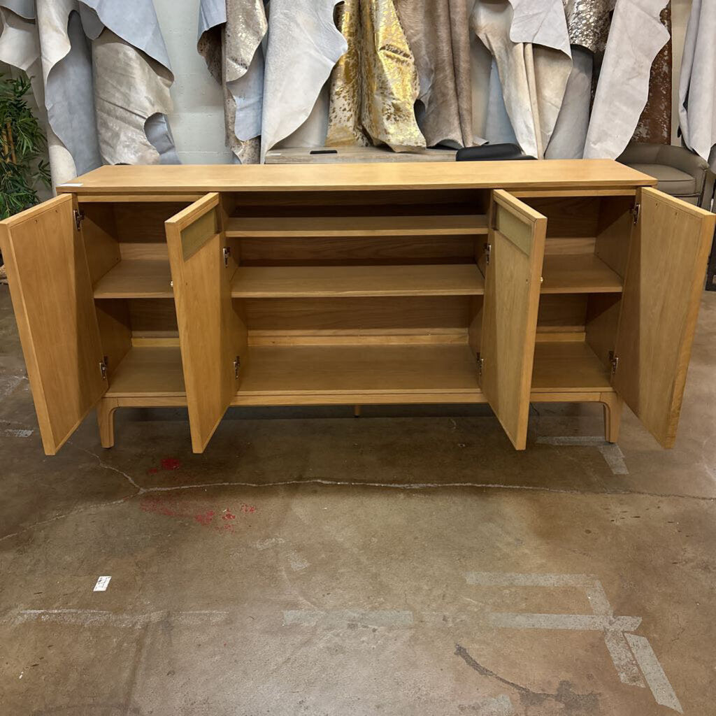 Wooden sideboard with open doors on a concrete floor