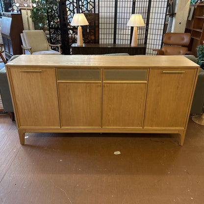 Wooden sideboard in a room with chairs and lamps