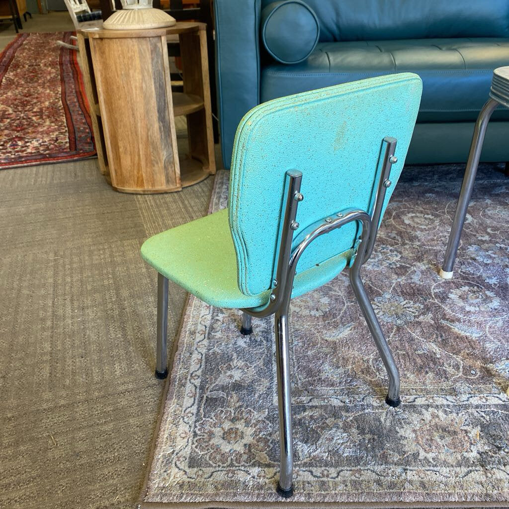 Blue and green chair with metal legs on a patterned rug