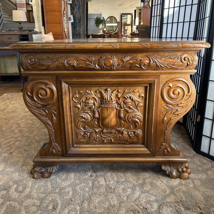 Carved wooden console table with intricate designs in a room setting.