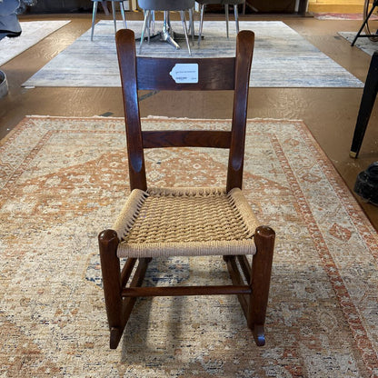Wooden chair with woven seat on a patterned rug