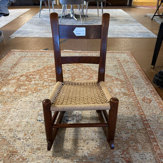Wooden chair with woven seat on a patterned rug