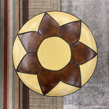 Decorative wall light fixture with brown and beige design on a textured wall background