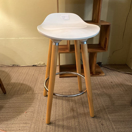 Bar stool with white seat and wooden legs on a carpeted floor.
