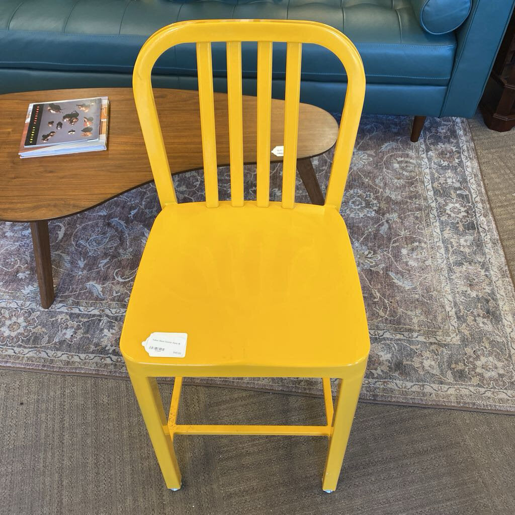 Yellow chair in a room with a blue couch and wooden table.
