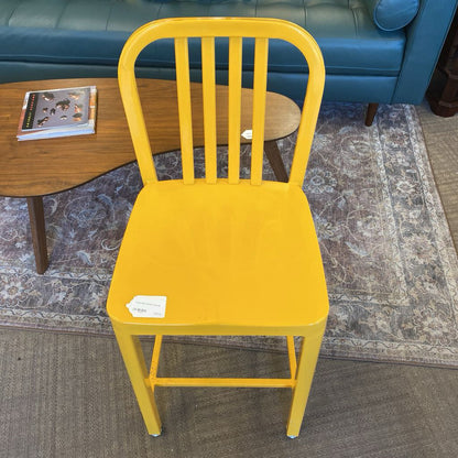 Yellow chair in a room with a blue couch and wooden table.