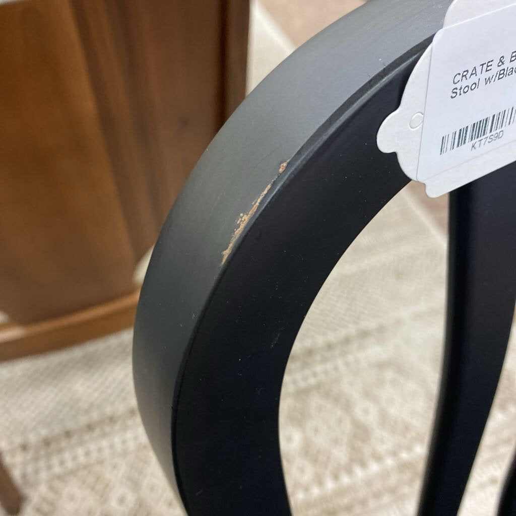 Black stool with a price tag on a carpeted floor