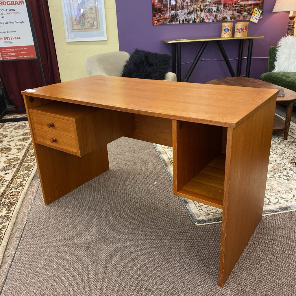Wooden desk in a room with a purple wall and various decor items.