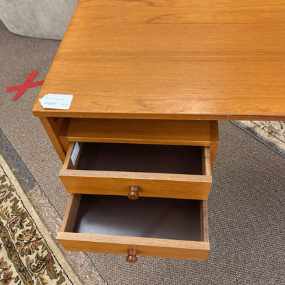 Wooden desk with an open drawer on a carpeted floor