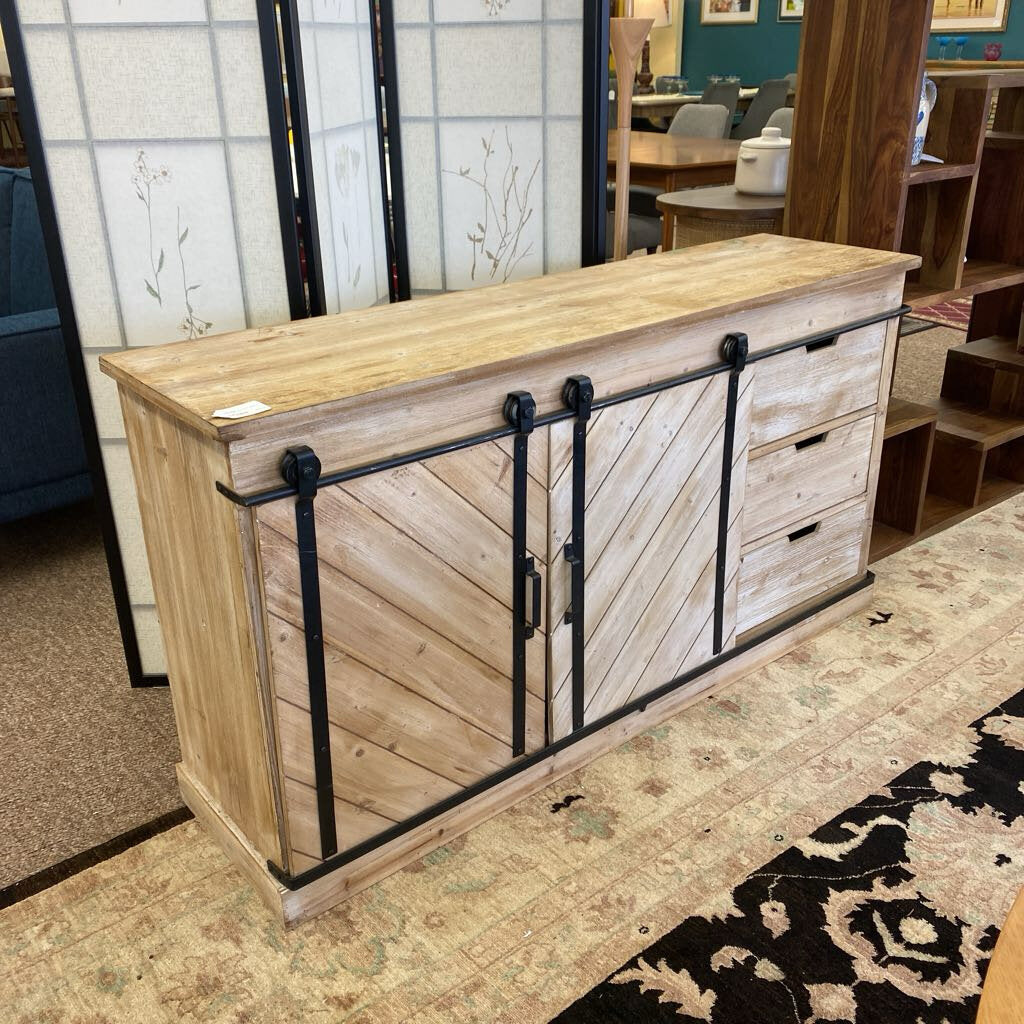 Wooden console table with sliding doors in a showroom setting