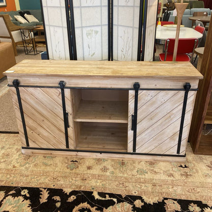 Wooden entertainment console with sliding doors in a store setting