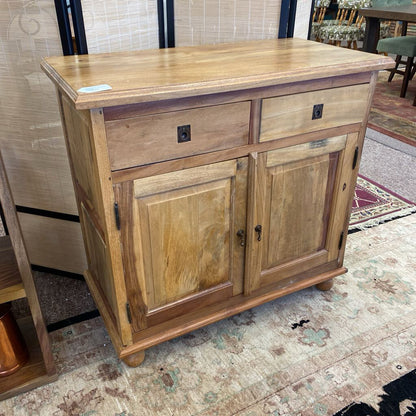 Wooden sideboard with two doors and a drawer on a patterned floor.