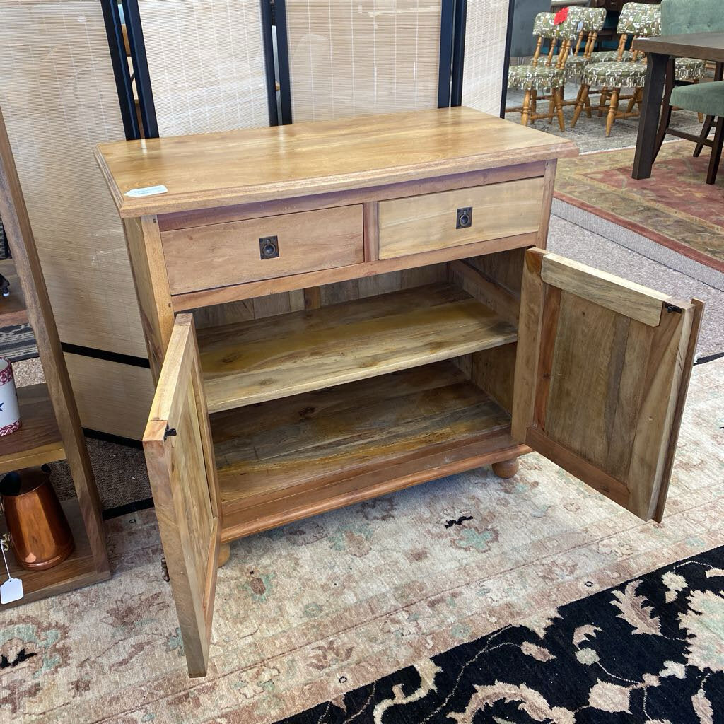 Wooden sideboard with open doors on a patterned rug
