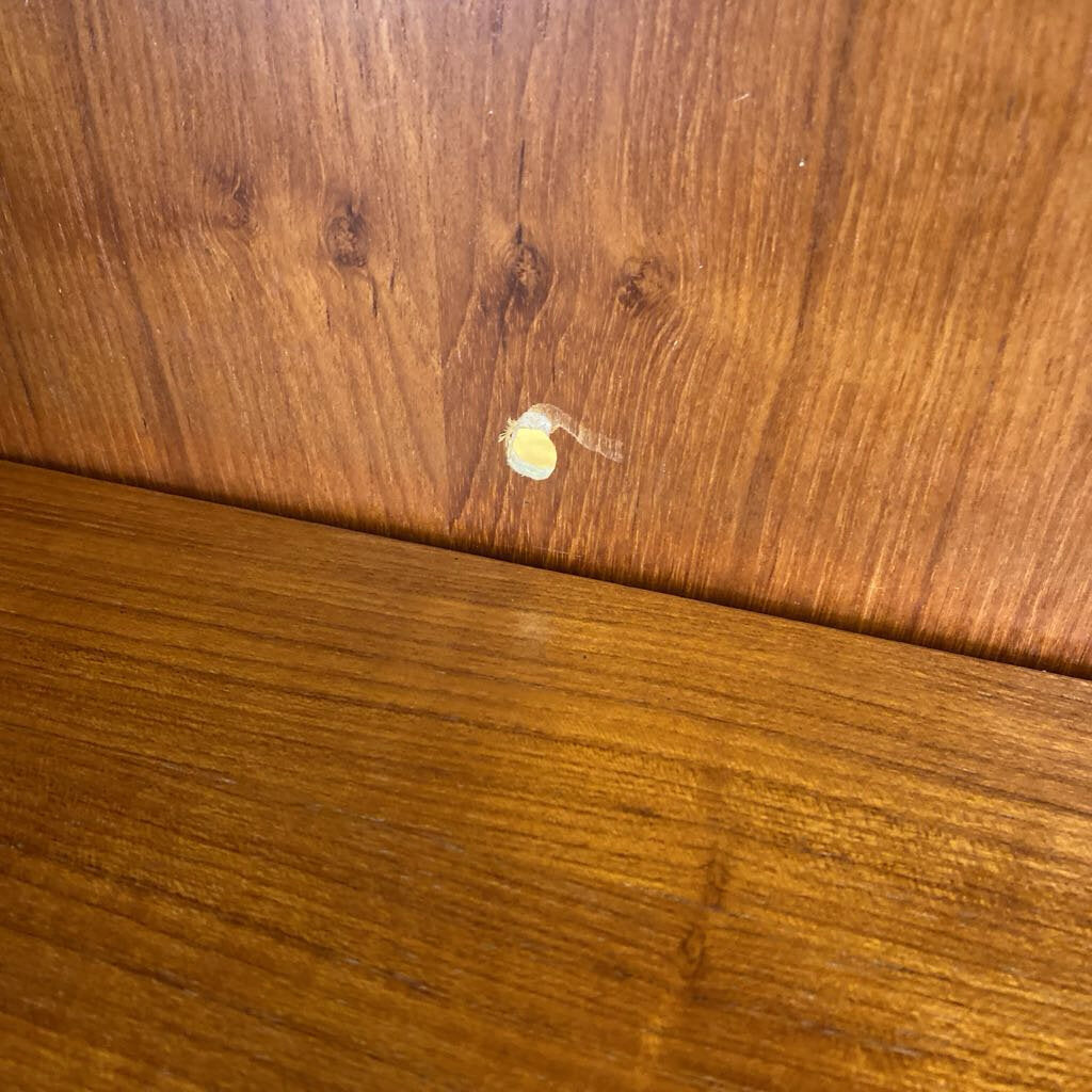 Close-up of a wooden surface with a small white object on it