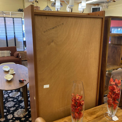 Wooden cabinet with 'Made in Denmark' inscription in a room setting.
