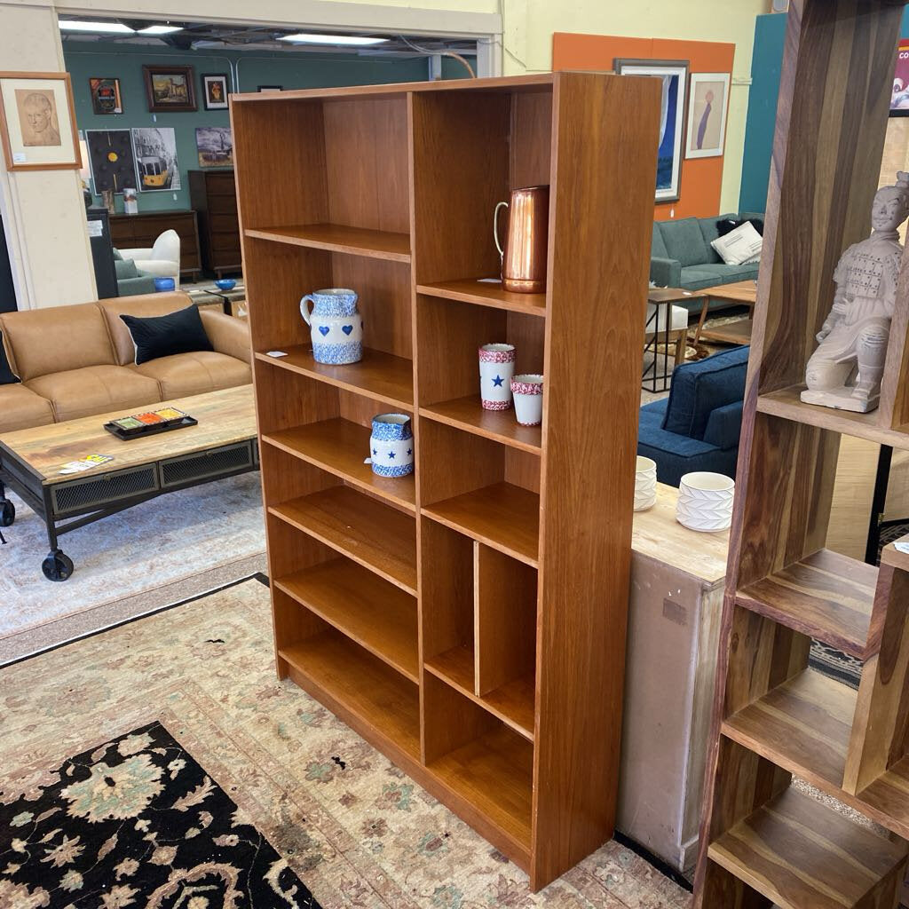 Wooden bookshelf in a living room setting with decor items on shelves