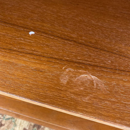 Close-up of a wooden surface with a scratch and a small white spot.