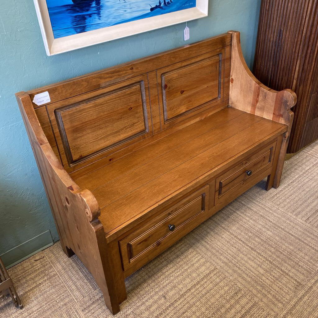 Wooden bench with storage drawers in a room with a blue wall and framed picture.