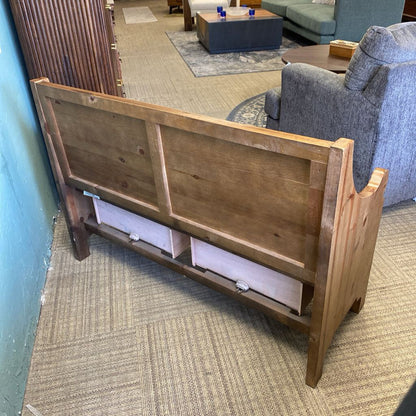 Wooden headboard against a wall in a room with furniture and decor.