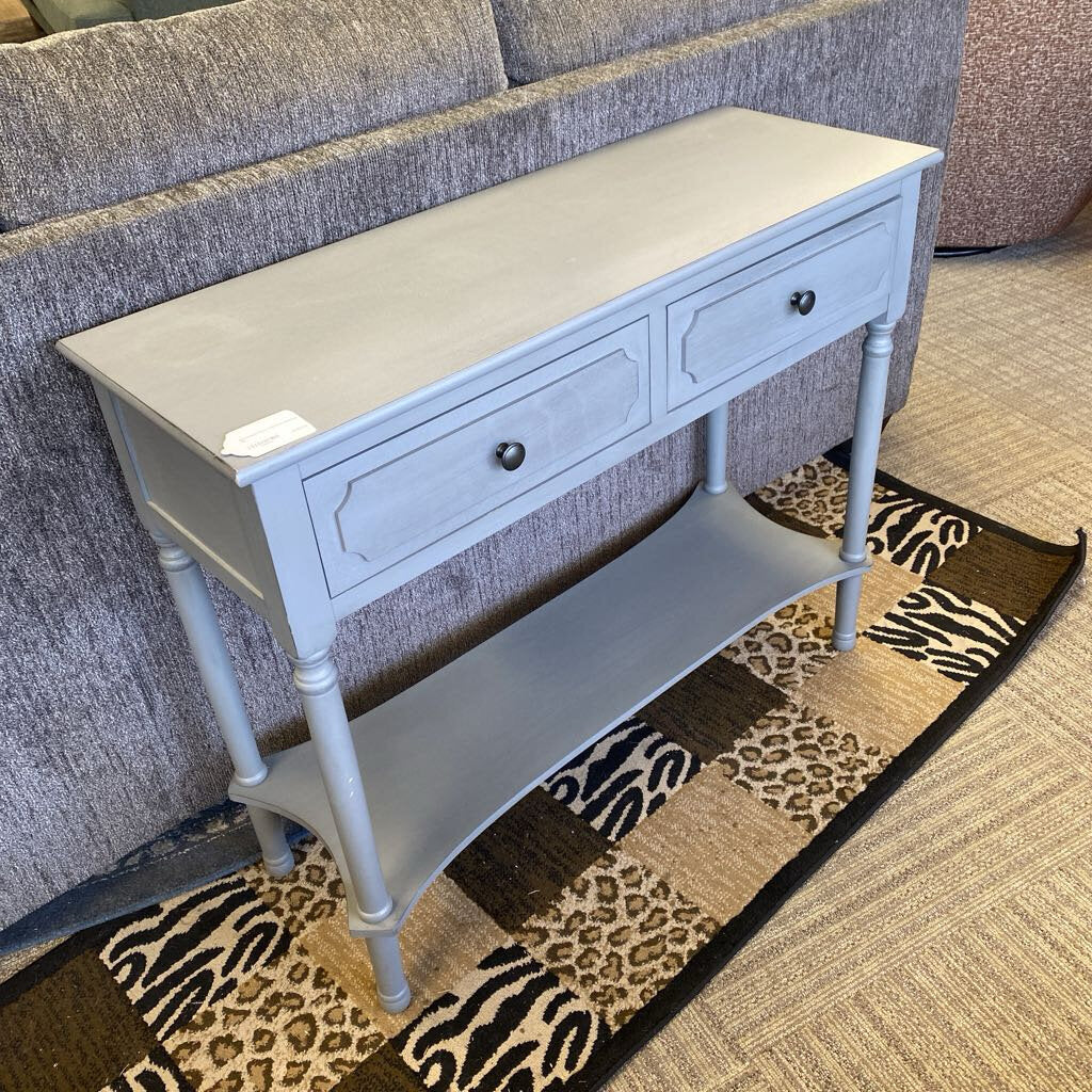 Light blue console table with two drawers and a shelf in a room setting.