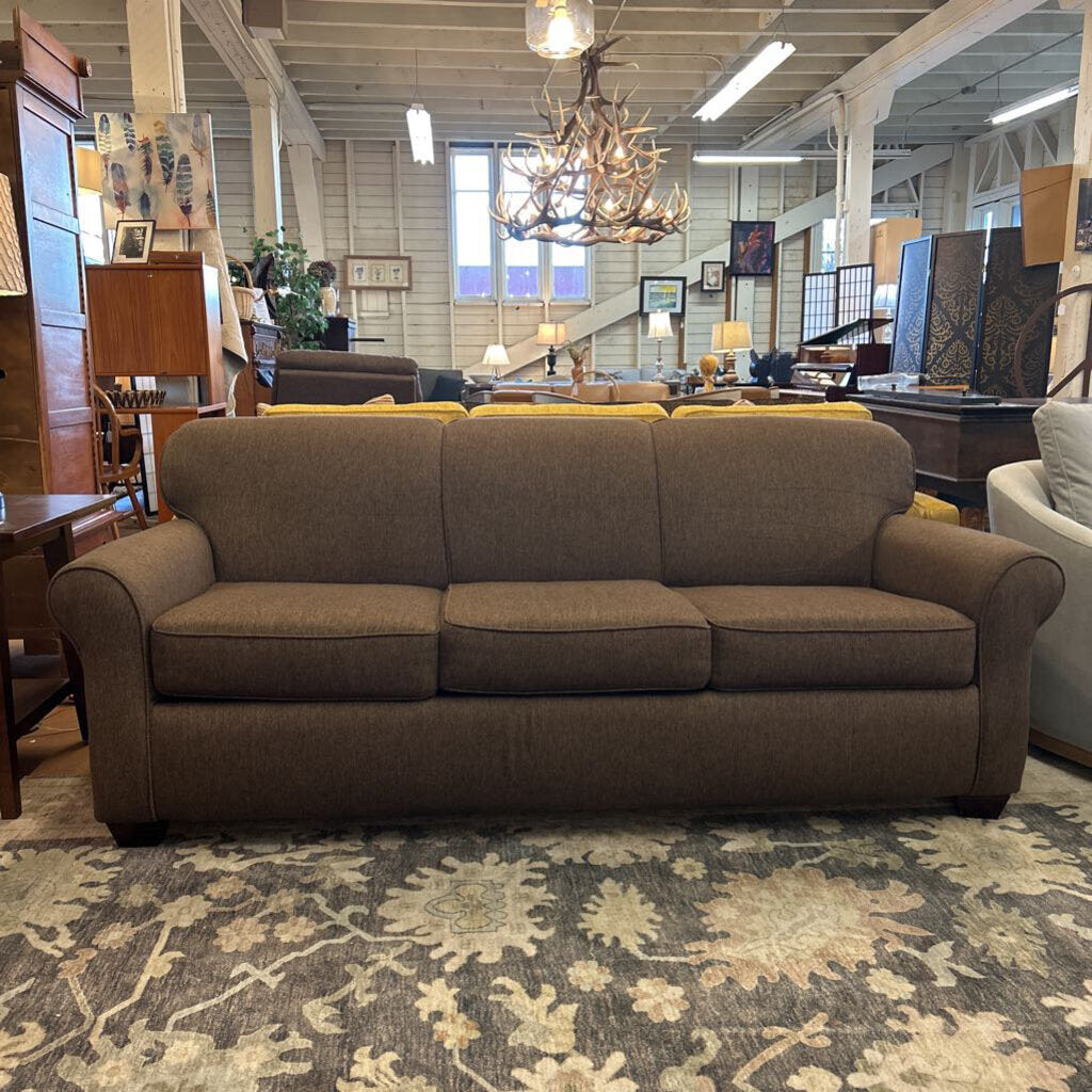 Brown sofa in a room with furniture and decor