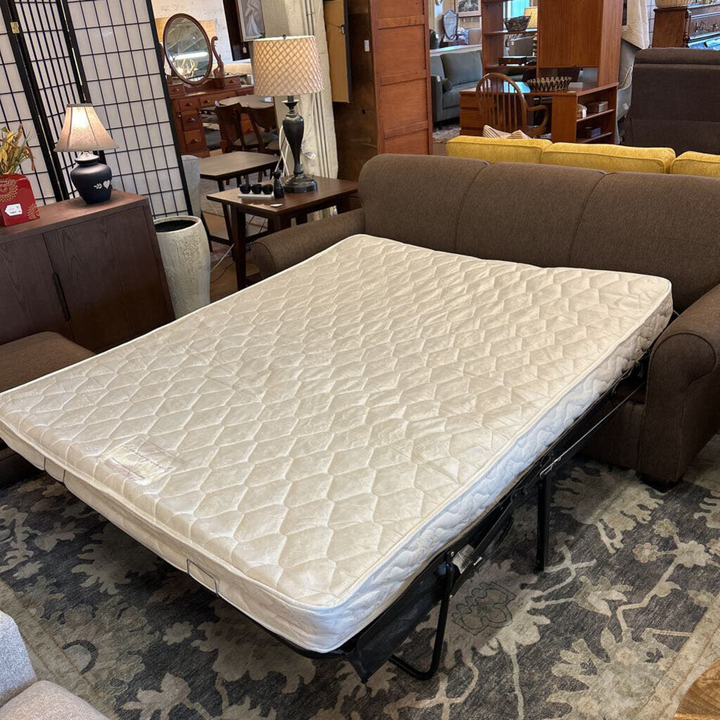 Mattress on a sofa bed in a living room setting with furniture and decor.