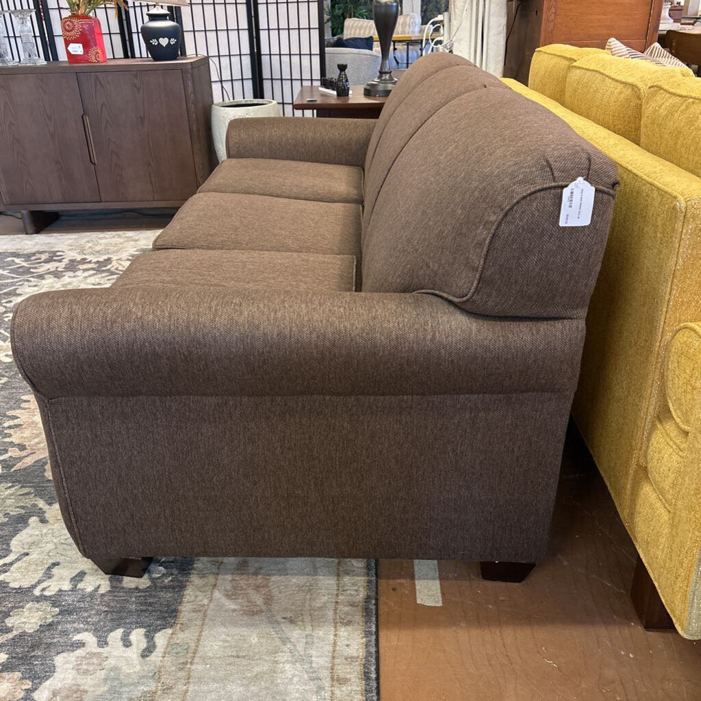 Brown sectional sofa with a price tag in a store setting