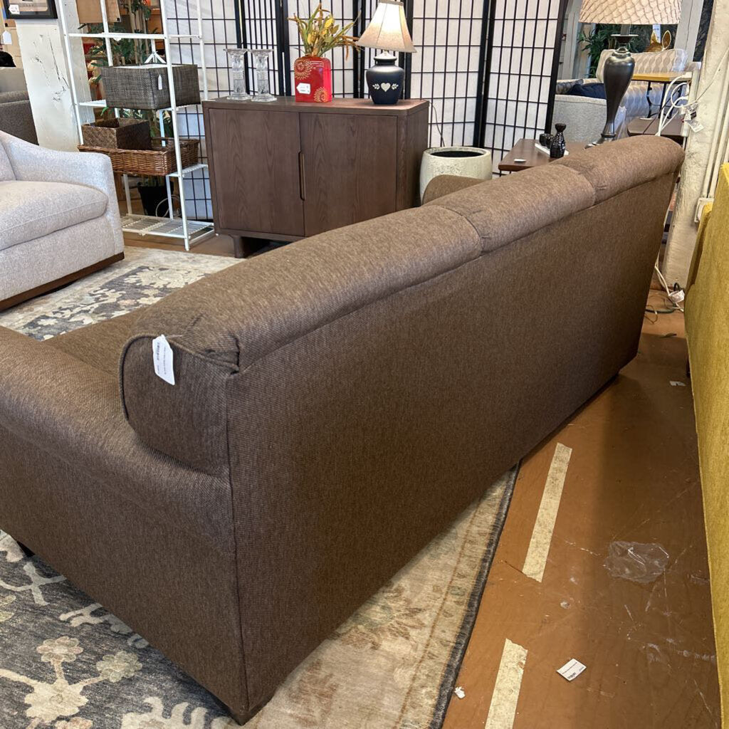 Brown sofa with a price tag in a showroom setting