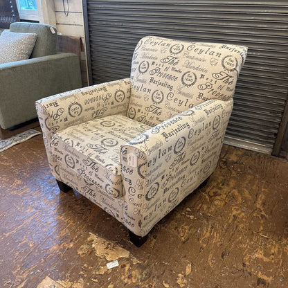 Patterned armchair on a wooden floor with a metallic shutter in the background