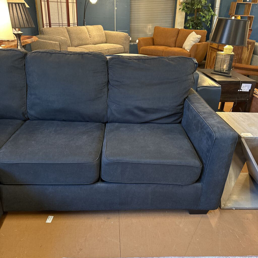 Blue sofa in a showroom with other furniture in the background