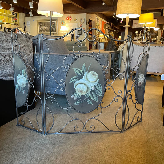 Decorative metal screen with floral designs in a room setting