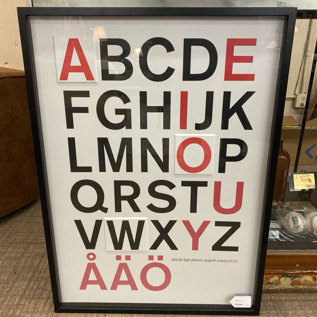 Framed alphabet poster with red and black letters on a white background