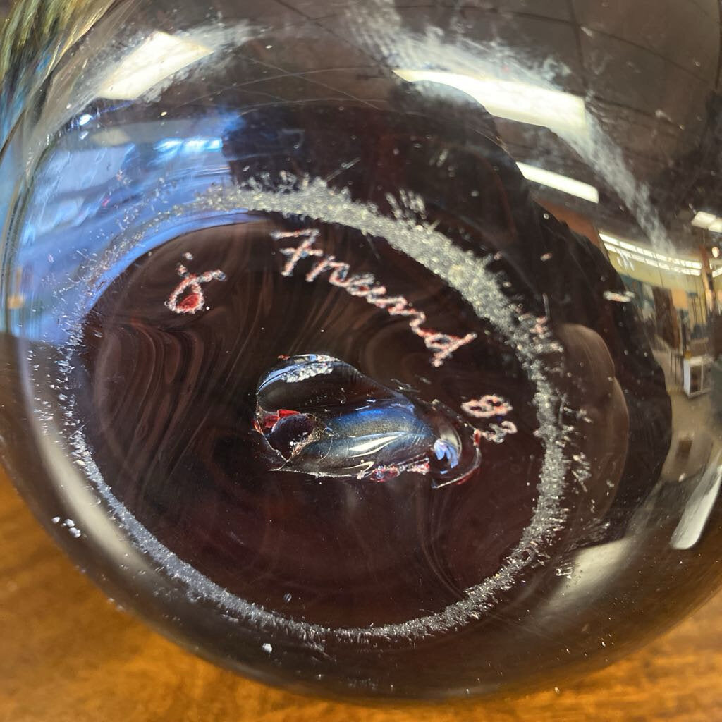 Decorative glass vase with blue and black patterns on a wooden surface