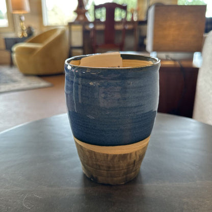 Blue and brown ceramic cup on a table with a blurred background of a room.