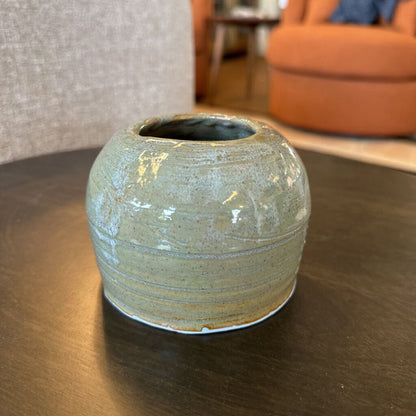 Ceramic vase on a wooden table with a blurred indoor background
