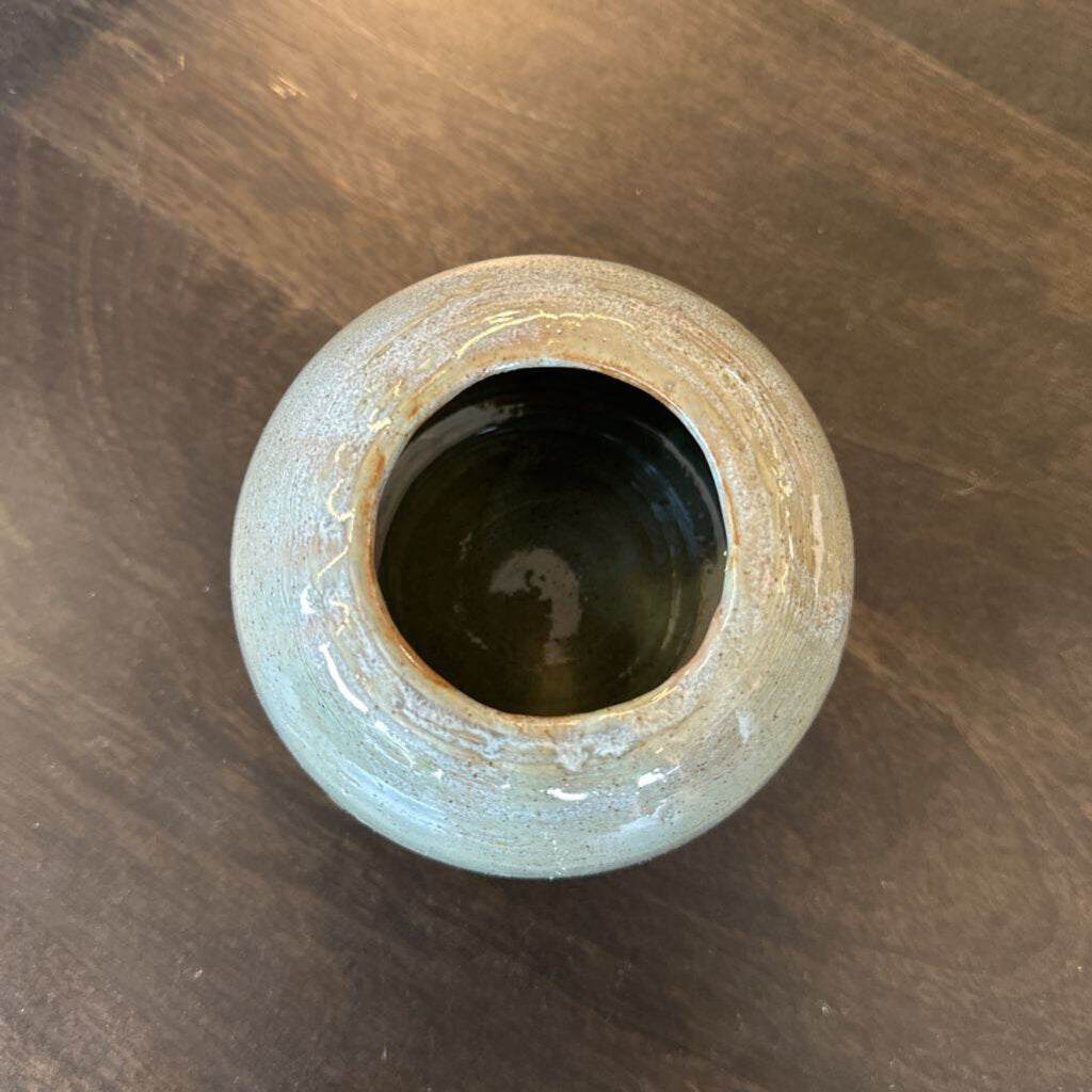 Small ceramic pot on a wooden surface