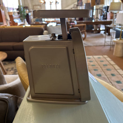 Pelouze coffee grinder on a table in a room with furniture and decor.