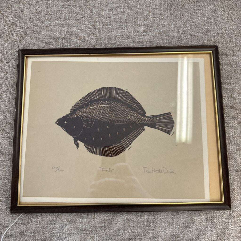 Framed artwork of a fish on a textured gray wall