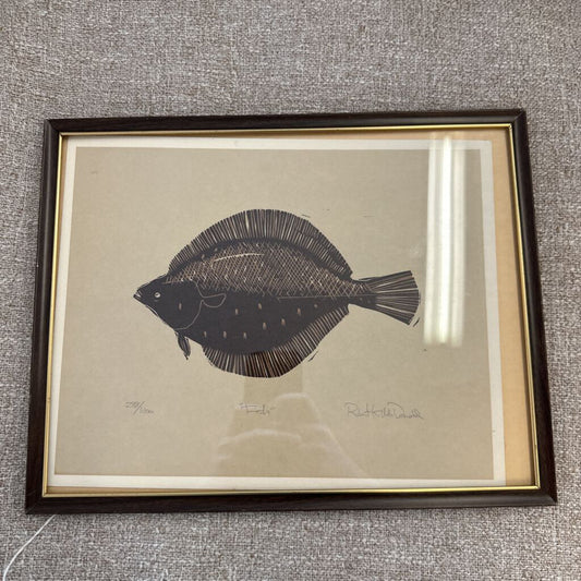 Framed artwork of a fish on a textured gray wall