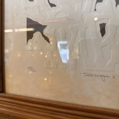 Framed artwork with a seascape design on a textured glass surface.